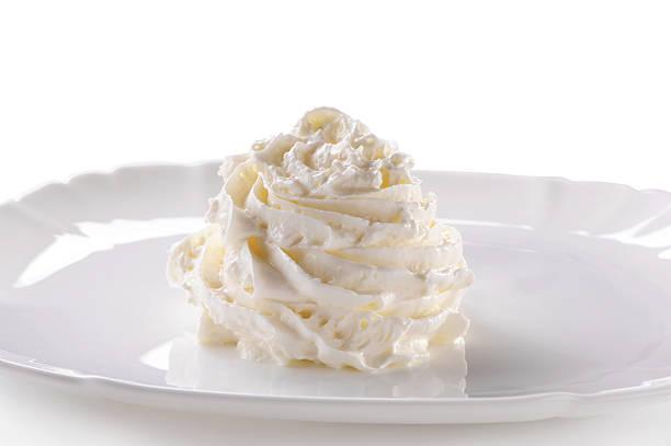 istock Whipped cream on porcelain plate close-up on white 629694262
