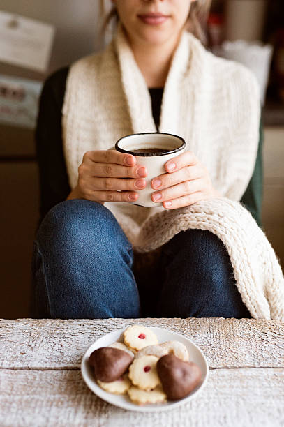 istock Unrecognizable woman with white knitted scarf holding coffee cup 629718352