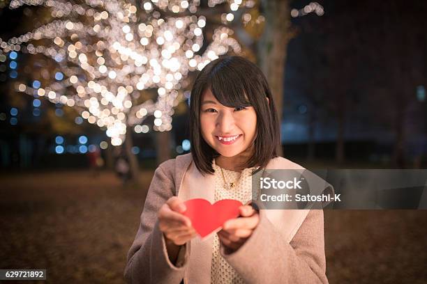 クリスマスの夜にカードを与える若い女性