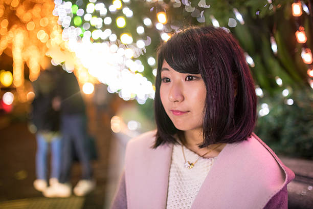 istock Young woman waiting for him under Christmas lights 629722138
