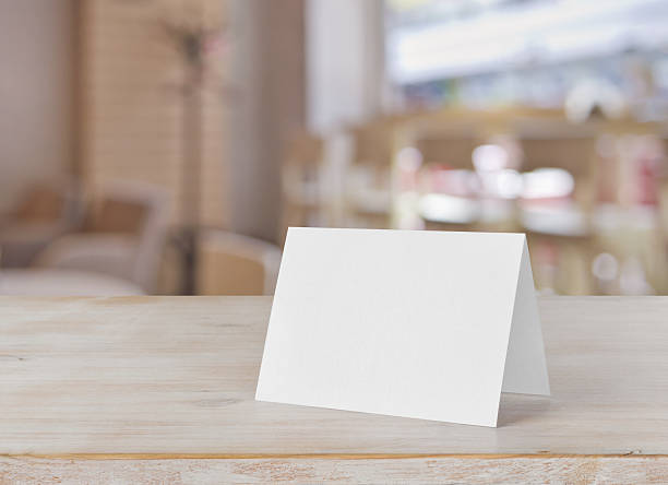 Blank paper table card on wooden table over bar background