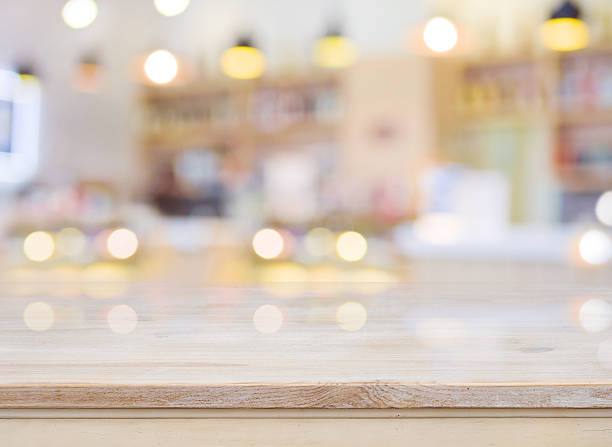 Blurred image of cafe interior with wooden table in front