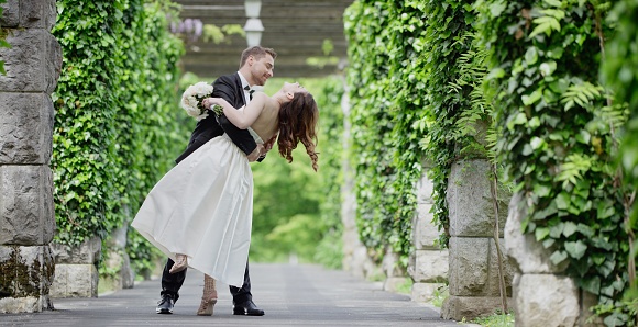 Bride and groom embracing and enjoying in park.