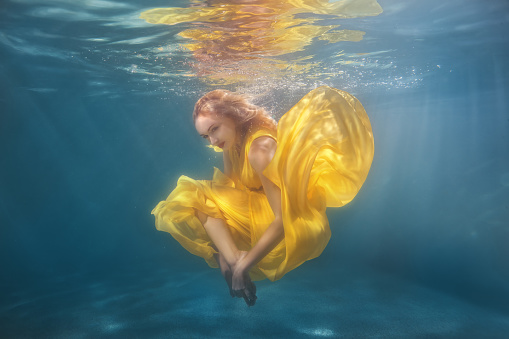 Woman dancing underwater.