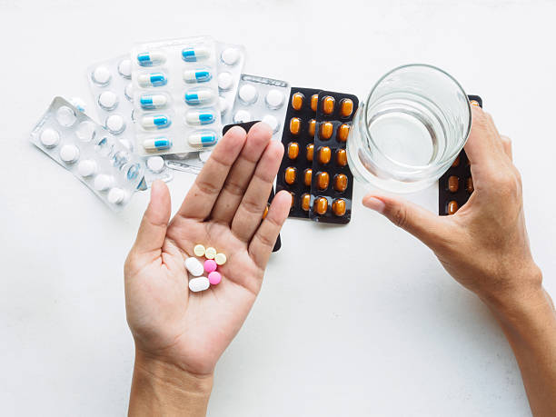 ruční držení vodní sklenice a léky k léčbě horečky - ganglion - stock snímky, obrázky a fotky