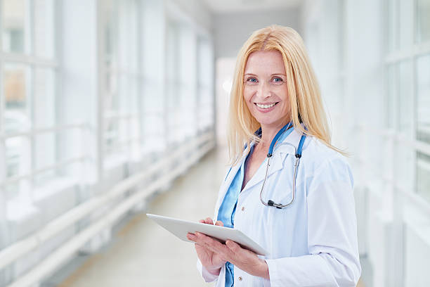 istock Happy female doctor with tablet 629726840