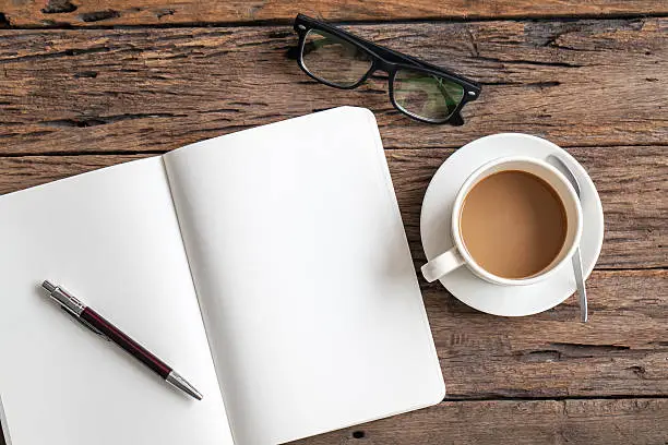 Photo of Blank paper with pen and cup of coffee