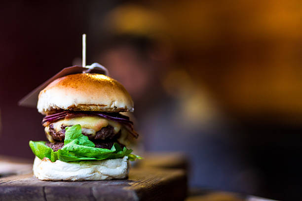 istock Fresh flame grilled burger with chef defocused in background 629734826