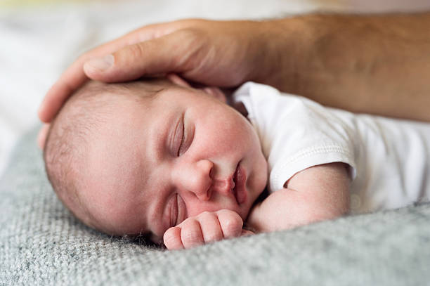 istock Unrecognizable father caressing his cute little newborn baby boy 629735566