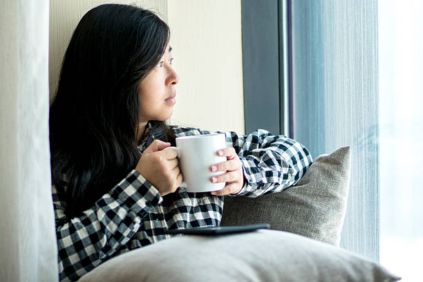 istock girl drinking coffee beside window 629737806