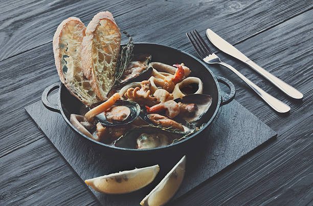 istock Seafood Stew in Saucepan on dark wood background 629740864