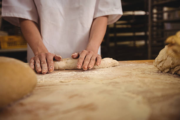 istock Mid-section of female baker kneading a dough 629743460