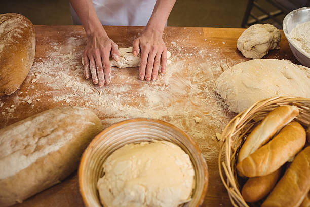 istock Hands of female baker kneading a dough 629743596