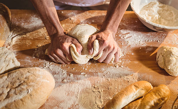 hände des bäckers kneten einen teig - bread kneading making human hand stock-fotos und bilder