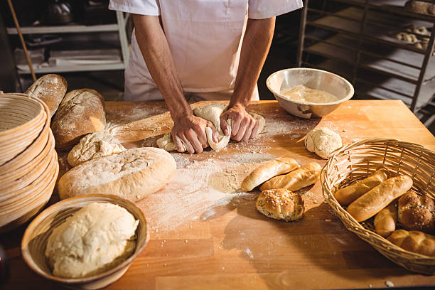 istock Mid-section of baker kneading a dough 629743776