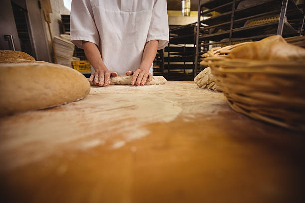 istock Mid-section of female baker kneading a dough 629744112