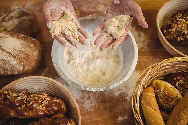 istock Hands of baker mixing flour by hand 629744334
