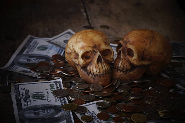 istock skull on bank note and coin 629744540