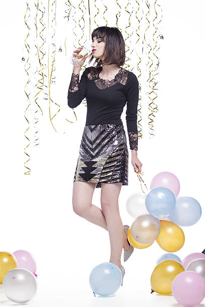 istock Beautiful woman elegantly dressed while having fun drinking champagne 629744818