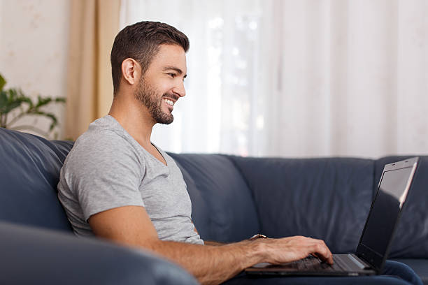 istock Side view of handsome young man using his laptop 629744918