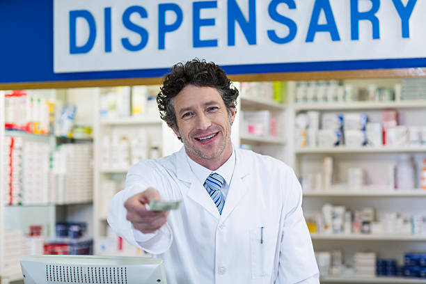 istock Pharmacist giving money to customer in pharmacy 629745836