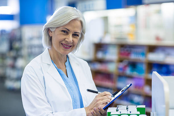 istock Pharmacist writing on clipboard in pharmacy 629746032