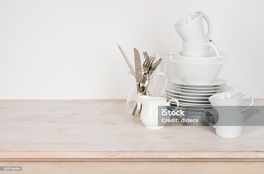 White dishware and cutlery on wooden table with copy space Crockery Stock Photo