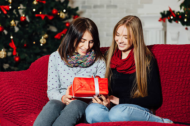 istock young beautiful girls sitting on a couch with 629757410