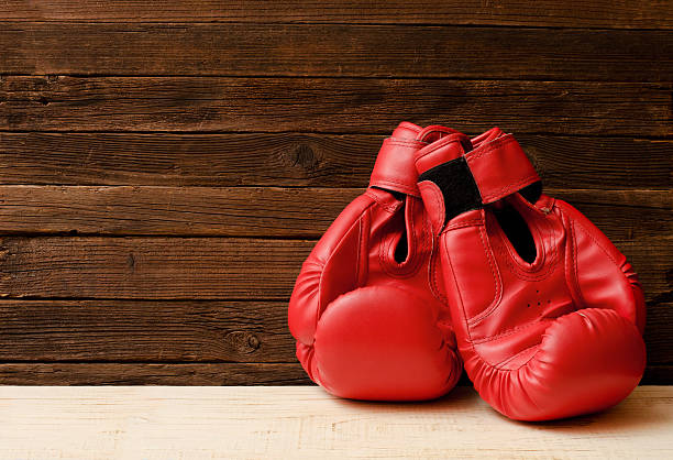 istock Two red boxing gloves on a wooden brown background 629758100