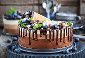 Three chocolate mousse cake decorated with waffle cone, fresh bl