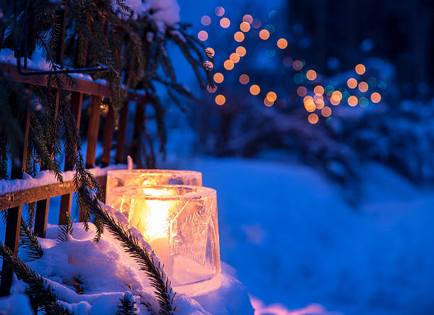 Ice lantern Traditional outdoor decoration in Finland in winter. The block of ice is usually made by leaving a bucket of water to stay outside overnight in cold temperature. The result is a hollow block of ice. Blurred fairy lights on the background. finnish culture stock pictures, royalty-free photos & images