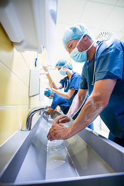 istock Group of surgeons washing their hands at washbasin 629761544