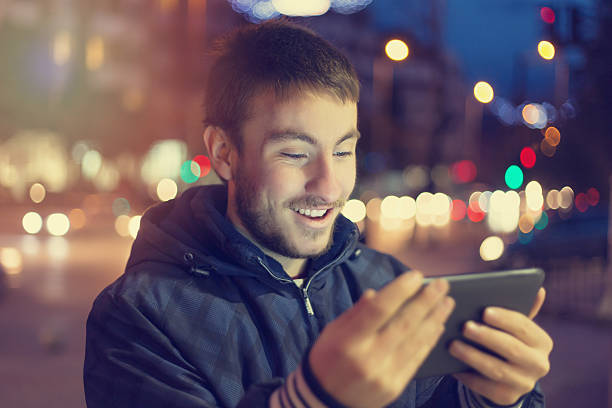 istock Teenager using digital tablet on streets by night 629762696