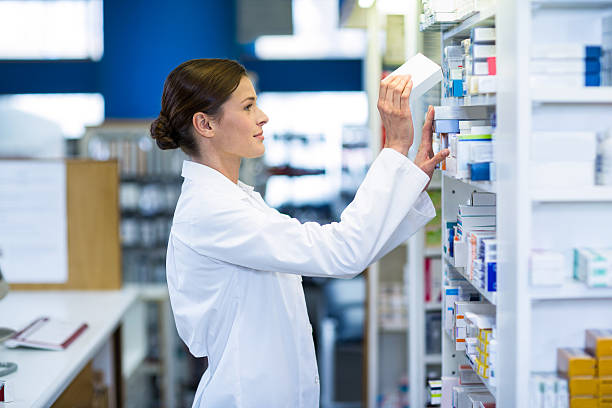 Pharmacist checking medicine in shelf Pharmacist checking medicine in shelf at pharmacy pharmacy photos stock pictures, royalty-free photos & images