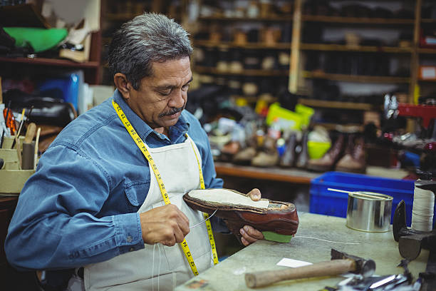 istock Shoemaker repairing a shoe 629764362