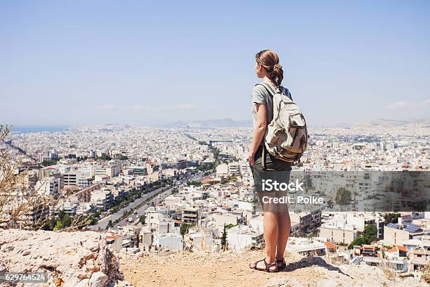 Mujer Joven Mirando En Un Viajero A La Ciudad Foto de stock y más banco de imágenes de Ciudad - Ciudad, Atenas - Grecia, Excursionismo