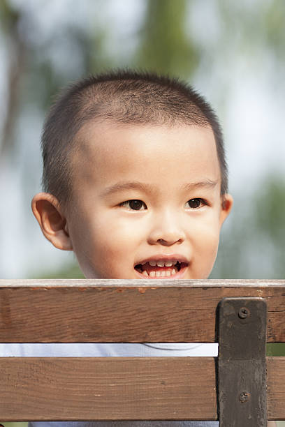istock Cute baby boy playing on a bench in a park 629764986