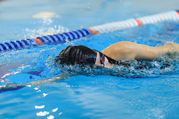 istock woman in goggles and cap swimming front crawl stroke style 629766478