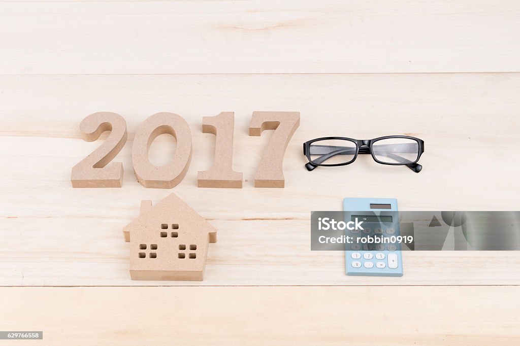 house, glasses,2017  ,Calculator in form of a house house, glasses,2017 and Calculator in the form of a house on a Wooden desk. top view 2017 Stock Photo