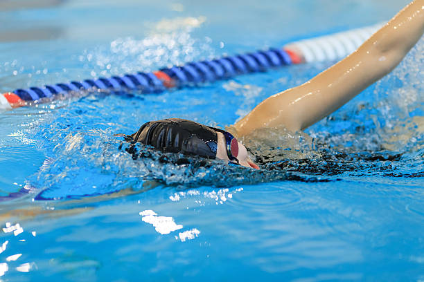 istock woman in goggles and cap swimming front crawl stroke style 629766604
