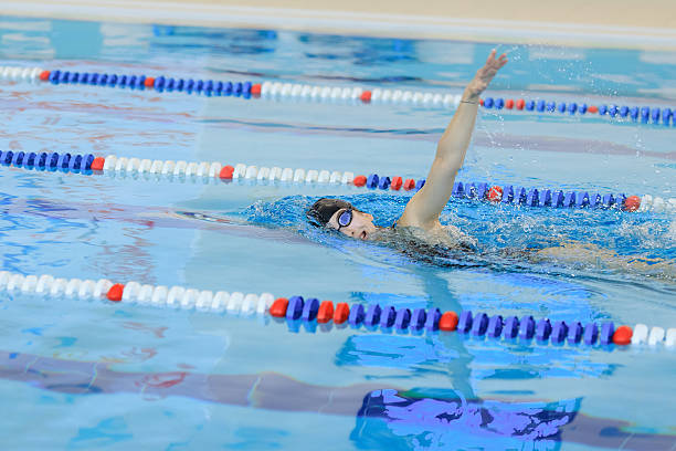 istock woman in goggles and cap swimming front crawl stroke style 629766808