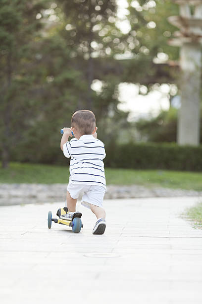 istock Happy Chinese baby boy playing a scooter 629766818