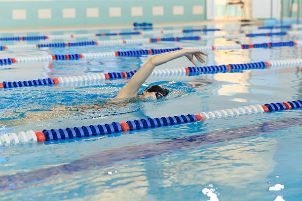 istock woman in goggles and cap swimming front crawl stroke style 629767086