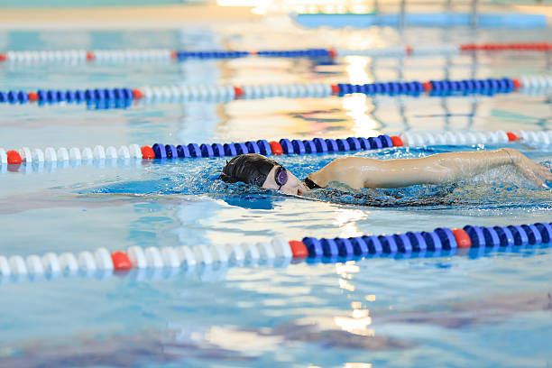 istock woman in goggles and cap swimming front crawl stroke style 629767184