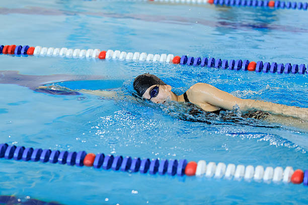 istock woman in goggles and cap swimming front crawl stroke style 629767412
