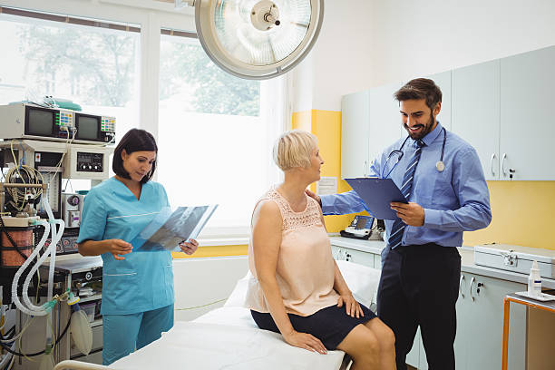 istock Male doctor interacting with a patient while nurse 629768032