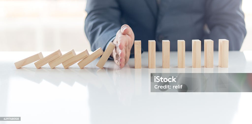 Businessman Stop Domino Effect. Risk Management and Insurance Concept Business Stock Photo