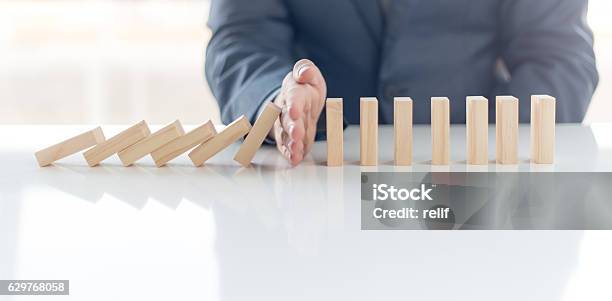 Businessman Stop Domino Effect Risk Management And Insurance Concept Stock Photo - Download Image Now