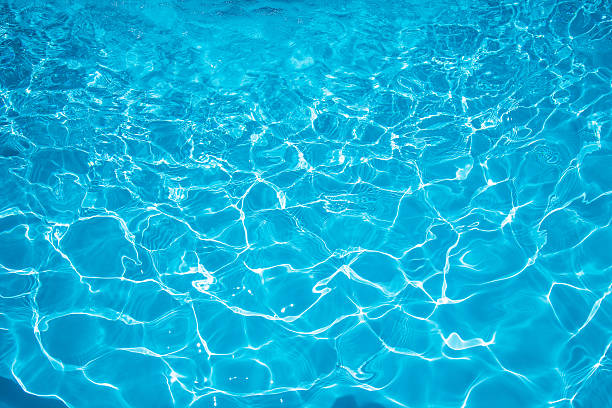 istock Beautiful blue water surface with sun reflection in swimming pool 629771484