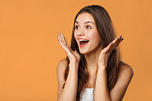 Surprised happy beautiful woman looking sideways in excitement. Isolated